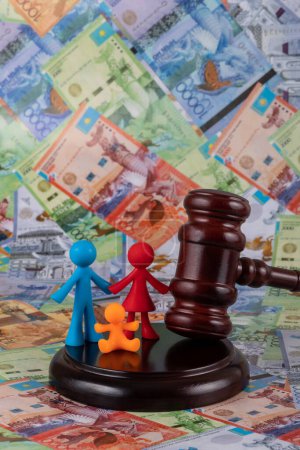 Téléchargez les photos : Judge's gavel and a symbolic family against the background of Kazakh banknotes - tenge - en image libre de droit