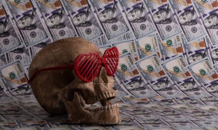 Menschlicher Schädel und Sonnenbrille in Form eines Herzsymbols auf dem Hintergrund amerikanischer Dollars