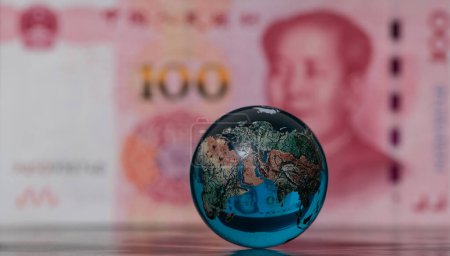 Foto de Globo de vidrio frente a un billete de 100 yuanes chinos - Imagen libre de derechos