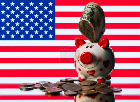Foto de Funny Piggy Bank, monedas estadounidenses y bandera estadounidense - Imagen libre de derechos