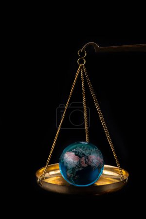 Photo for Glass globe on a scale on a black background - Royalty Free Image