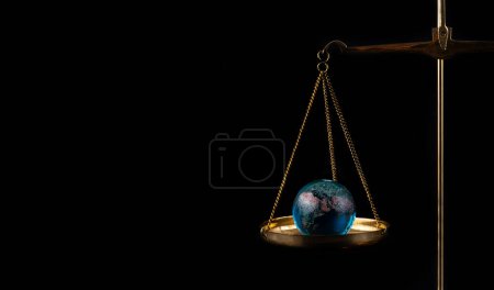 Photo for Glass globe on a scale on a black background - Royalty Free Image