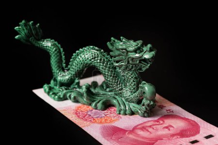 Symbolic dragon figurine and 100 Chinese yuan note
