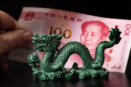 Figura dragón simbólico y nota de 100 yuanes chinos