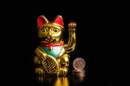 Classic Chinese cat figurine bringing financial prosperity and 1 US dollar coin