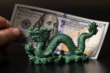 Traditionelle Figur des symbolischen chinesischen Drachen und 100-Dollar-Schein