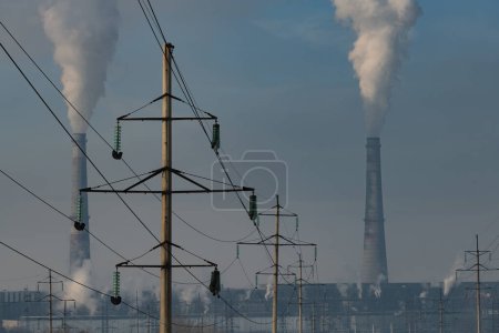 Téléchargez les photos : Centrale thermique au charbon fumeur et lignes de transport d'électricité à haute tension un jour d'hiver - en image libre de droit