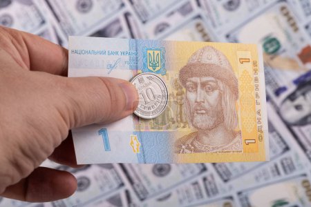 Dinero ucraniano - hryvnia en el contexto de billetes de 100 dólares estadounidenses