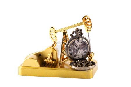 Golden miniature oil pump and vintage pocket watch on white background