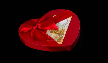 A 100 Russian ruble banknote and a gift box in the shape of a human heart