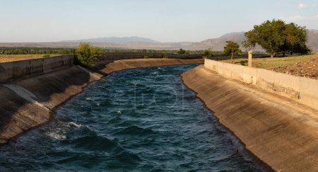 Grand canal d'irrigation artificiel rempli d'eau par une journée ensoleillée