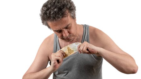Photo for A gray-haired, shaggy, unshaven middle-aged man in a sleeveless T-shirt holds a 100 Russian ruble bill - Royalty Free Image