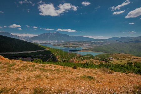 Photo for Beautiful panorama of the city of Kukes in northern Albania, summer weather with some clouds over the sky with majestic Sasati and Plinas Stiqen mountains behind and Drin reservoir in the foreground. - Royalty Free Image