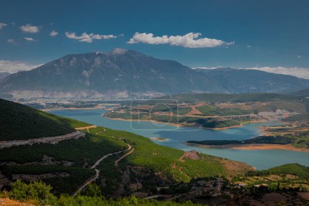Photo for Beautiful panorama of the city of Kukes in northern Albania, summer weather with some clouds over the sky with majestic Sasati and Plinas Stiqen mountains behind and Drin reservoir in the foreground. - Royalty Free Image