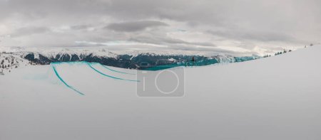 Téléchargez les photos : Wide panorama of big air kicker jump at zoncolan ski area on a cloudy day. Ski jumps made ready and perfectly shaped. - en image libre de droit