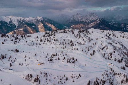 Téléchargez les photos : Aerial drone panorama of Zoncolan ski resort in northern Italy on a cloudy winter day. Visible mountains around, good visibility. - en image libre de droit