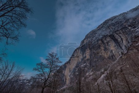 Téléchargez les photos : View from the Lauterbrunnen valley towards epic stone rock walls rising up from the valley. Dark blue skies - en image libre de droit