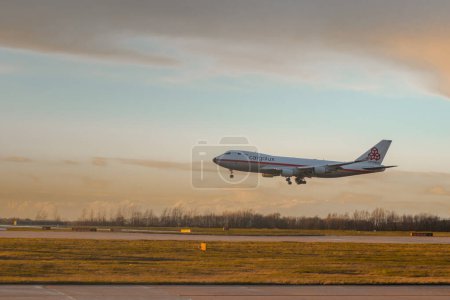Photo for GLASGOW, UK, 24.3.2023: Cargolux 747 freighter jet is landing on glasgow airport in early morning with beautiful strong backlight - Royalty Free Image