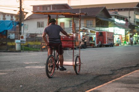 Photo for Unknown street vendor on a trycycle rolling on the main street of Bocas Del Toro island village, touristic spot in the panama part of caribbean. - Royalty Free Image