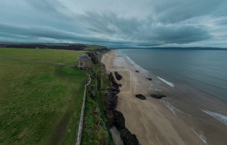 Foto de Playa cerca de Castlerock, Irlanda del Norte, en un hermoso tramo de playa de arena con un gran acantilado al lado. Tiempo tormentoso acercándose. - Imagen libre de derechos