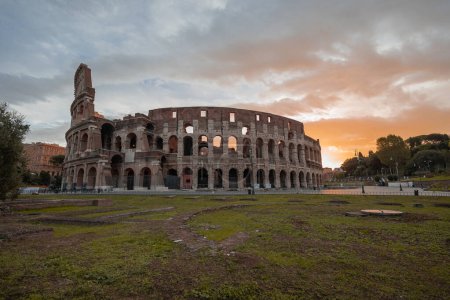 Téléchargez les photos : Tôt le matin vue sur le Colisée de Rome, ciel rouge et bleu avec soleil sur le point de se lever au-dessus du grand amphithéâtre célèbre. Réglage d'automne. - en image libre de droit