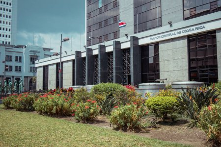Téléchargez les photos : Banque ou siège d'une banque centrale de Costa Rica, buissons verts visibles en face du bâtiment et façade blanche propre - en image libre de droit