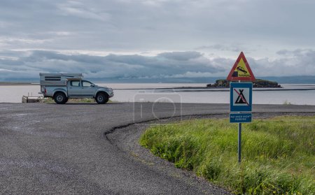 Camping-car d'aventure stationné sur une place de stationnement pas plus de nuit sur une partie pittoresque de la route en Islande. Beau paysage sur le véhicule d'atterrissage garé.