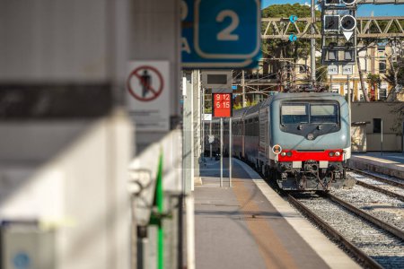 Tren de pasajeros que llega a la estación de Brindisi en el sur de Italia, Puglia. Tren acercándose a la plataforma 2 en un soleado día de primavera.