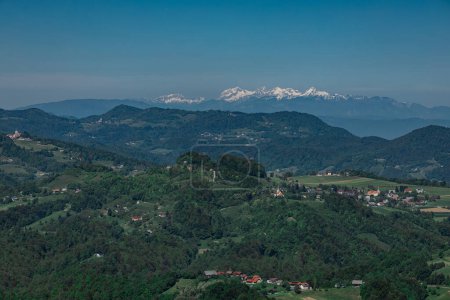 Slowenische Landschaft und Alpen vom stolp ljubezni oder Turm der Liebe aus, hölzerner Aussichtspunkt in der Nähe von Sentjur pri Celju. Sonniger Tag, grüne Hügel und Wälder in Slowenien