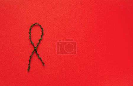 Foto de Green ribbon on red background, top view with space for text. Domestic violence awareness - Imagen libre de derechos