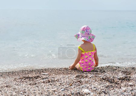Photo for Cute little girl looking sea in rear view - Royalty Free Image