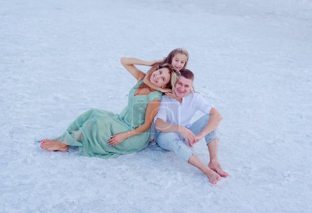 Foto de Feliz familia en la playa. Gente divirtiéndose en vacaciones de verano. Padre, madre e hijo contra el fondo del mar y del cielo. Concepto de viaje - Imagen libre de derechos