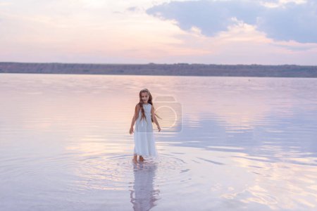 Photo for Little girl walking on beautiful ocean beach - Royalty Free Image