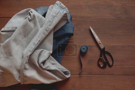 Photo for Denim Upcycling Ideas, Using Old Jeans, Repurposing Jeans, Reusing Old Jeans, Upcycle Stuff. Stack of old blue jeans and sewing tools - Royalty Free Image
