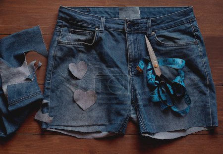 Foto de Denim Upcycling Ideas, Usando Vaqueros Viejos, Repurposing Jeans, Reutilizando Vaqueros Viejos, Upcycle Stuff. Pila de vaqueros azules viejos y herramientas de costura - Imagen libre de derechos