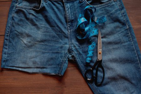 Téléchargez les photos : Recycler les vieilles ordures en denim. Recyclage de vieux jeans. Empilement de vieux jeans bleus, pièces coupées prêtes pour le recyclage et ciseaux. Économie circulaire. Une pile de vieux jeans bleus jetés. Zéro déchet - en image libre de droit