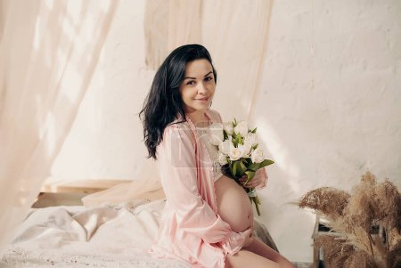 Foto de Mujer feliz embarazada tocando su vientre. Retrato de madre embarazada de mediana edad, acariciando su vientre y sonriendo. Concepto de embarazo saludable - Imagen libre de derechos