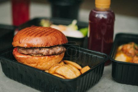 Foto de Street food. Meat cutlet burgers are in paper boxes. Food delivery. - Imagen libre de derechos