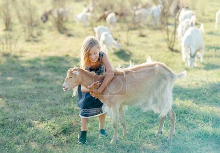 Téléchargez les photos : Agriculteur avec de petites chèvres sur la ferme caprine - en image libre de droit