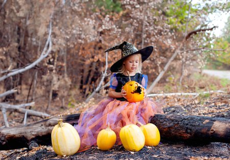Foto de Divertida niña en traje de bruja para Halloween con calabazas - Imagen libre de derechos