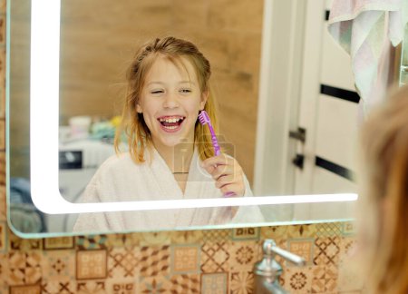 Foto de Higiene dental. Feliz niñita cepillándose los dientes. Rutina matinal. - Imagen libre de derechos