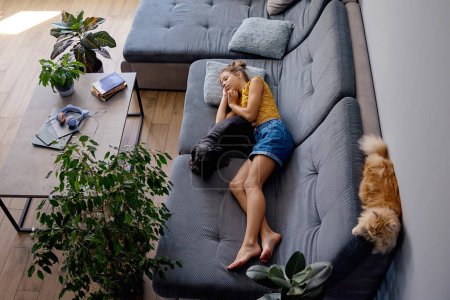 Photo for Girl resting on the sofa with animals - Royalty Free Image