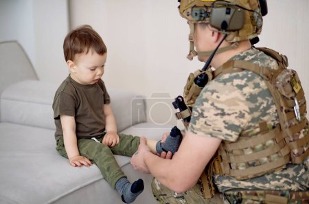 Ukrainian soldier in military uniform helps a child