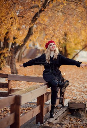 Foto de Hermosa mujer feliz relajándose en el parque de otoño. Balance y armonía con la naturaleza - Imagen libre de derechos