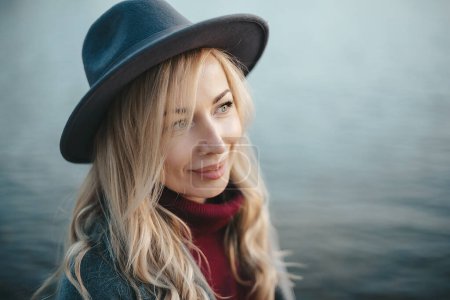 Téléchargez les photos : Gros plan portrait d'une belle fille souriante aux cheveux blonds portant un chapeau à l'extérieur - en image libre de droit