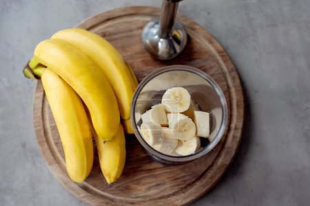 Téléchargez les photos : Mélangeur dans une vue de dessus, avec des tranches de bananes pour un smoothies à la banane. Concentration sélective sur les tranches de bananes et fond flou. - en image libre de droit