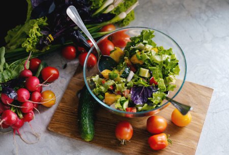 Téléchargez les photos : Salade de légumes sains de tomates fraîches, concombre, oignon, épinards, laitue sur assiette. Menu Régime alimentaire - en image libre de droit