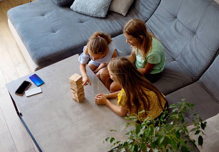 Photo for Family playing board game at home. Fun indoor activity for summer vacation. Educational toys. - Royalty Free Image