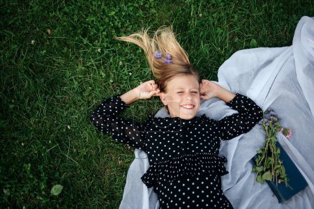 Téléchargez les photos : Portrait vue du dessus d'une jolie fille se relaxant sur une herbe - en image libre de droit