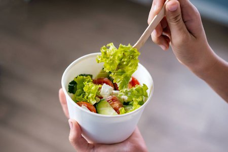 Foto de Greek salad in paper bowl for take away, top view - Imagen libre de derechos